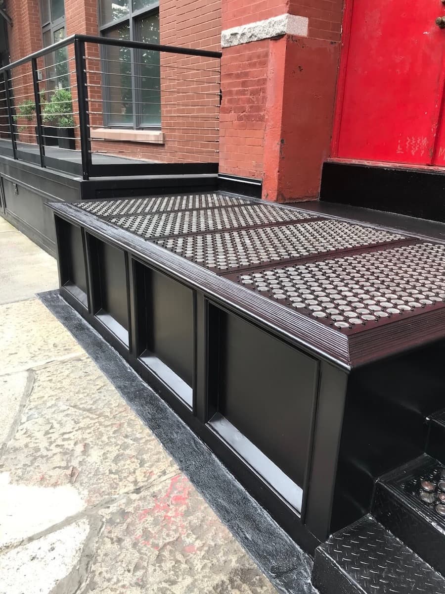 Restored black cast-iron vault light platform on a sidewalk