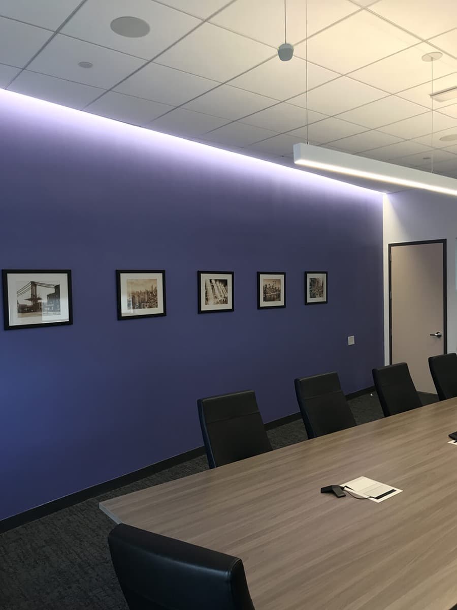 Conference room with a deep blue accent wall and framed pictures, freshly painted