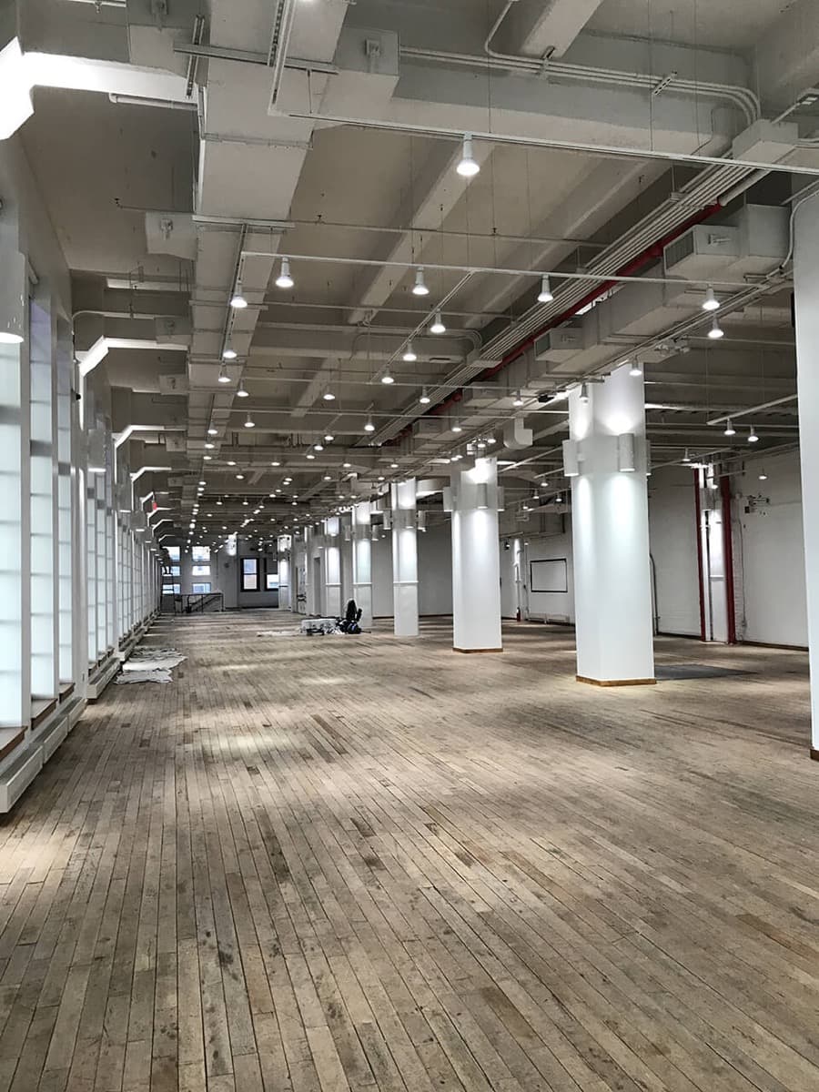 Wide hardwood floor in a long open loft with columns